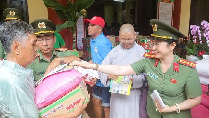 Lãnh đạo Phòng Nghiệp vụ Công an tỉnh trao quà tặng người dân. (Ảnh: PHƯỚC THANH)