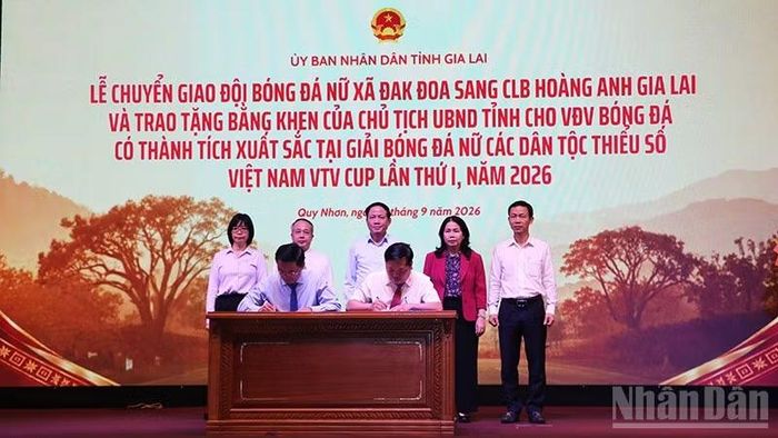 Đại diện Câu lạc bộ Hoàng Anh Gia Lai, lãnh đạo xã Đak Đoa thực hiện nghi lễ ký chuyển giao. (Ảnh: PHÚC THẮNG)