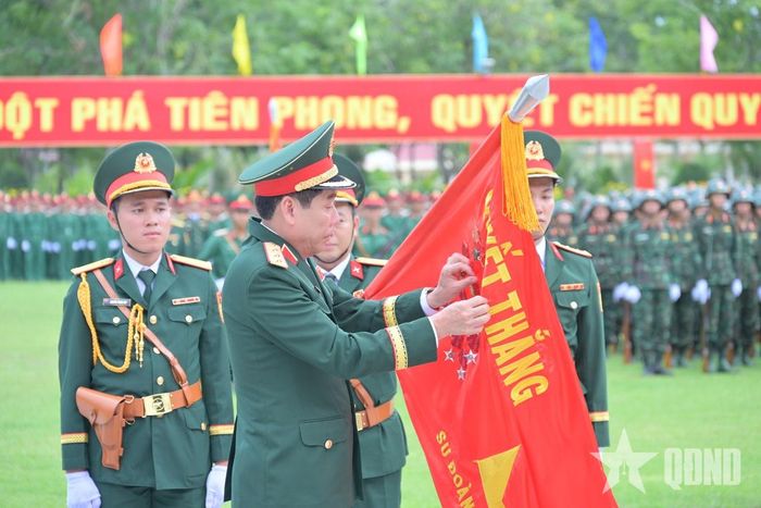 Thượng tướng Nguyễn Văn Gấu gắn Huân chương Bảo vệ Tổ quốc hạng Nhất lên Quân kỳ Quyết thắng.