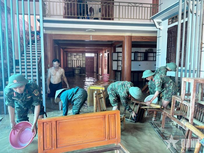 Cán bộ, chiến sĩ Trung đoàn 48, Sư đoàn 390 (Quân đoàn 12) giúp các hộ dân dọn dẹp, vệ sinh nhà cửa sau khi nước lũ rút.