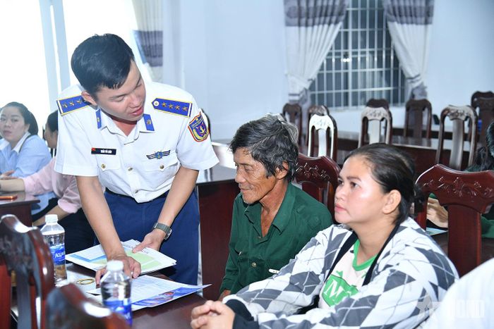 Cán bộ phát tờ rơi tuyên truyền chống khai thác IUU cho ngư dân.