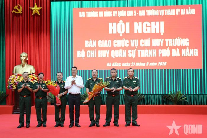 Các đại biểu tặng hoa chúc mừng Đại tá Nguyễn Thế Vinh (thứ 3 từ trái qua) và Đại tá Trần Hữu Ích (thứ 3 từ phải qua).