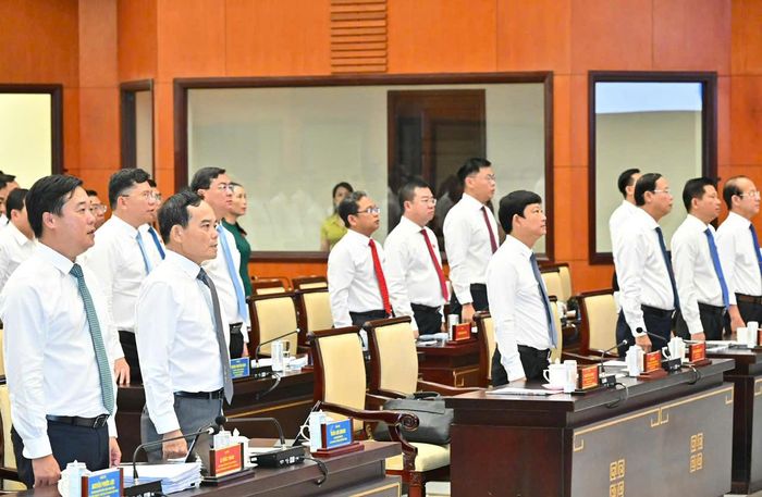  Các đại biểu thực hiện nghi thức chào cờ trước khi khai mạc kỳ họp. Ảnh: VIỆT DŨNG 