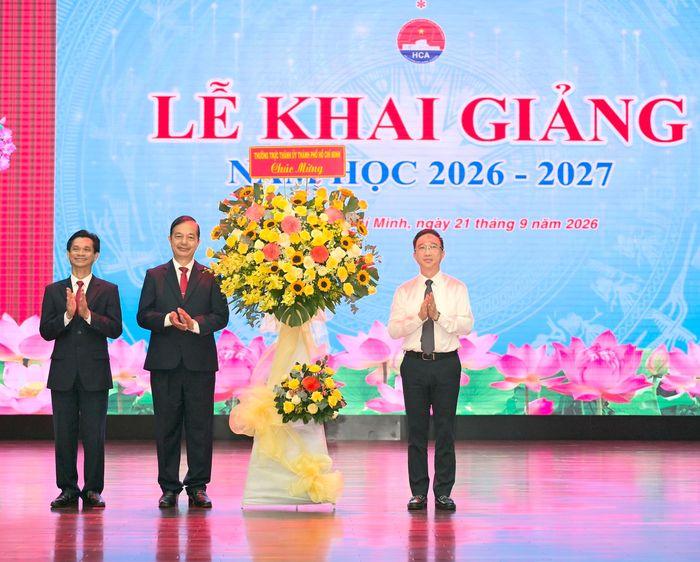 Phó Bí thư Thành ủy TPHCM Đặng Minh Thông trao lẵng hoa Thường trực Thành ủy TPHCM chúc mừng lễ khai giảng. Ảnh: VĂN MINH