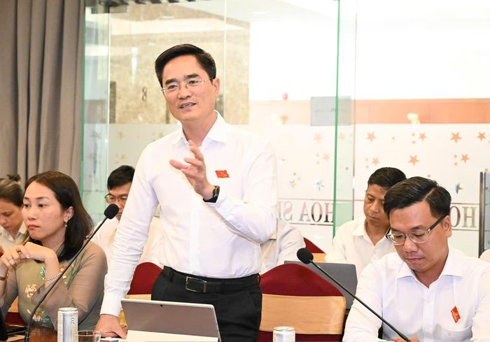 Giám đốc Sở Xây dựng Trần Quang Lâm trao đổi ý kiến với đại biểu. Ảnh: VIỆT DŨNG