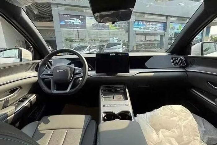 Bên trong xe, BYD Sealion 5 sở hữu thiết kế không quá nổi bật với chất liệu giả da màu xám đậm, đi kèm các đường chỉ khâu màu cam tương phản và những chi tiết crôm làm điểm nhấn. Cửa sổ trời toàn cảnh góp phần giảm bớt cảm giác tối cho nội thất. Tại thị trường Thái Lan, mẫu SUV này có những trang bị đáng chú ý như vô lăng bọc da tích hợp phím chức năng, ghế lái chỉnh điện 6 hướng.