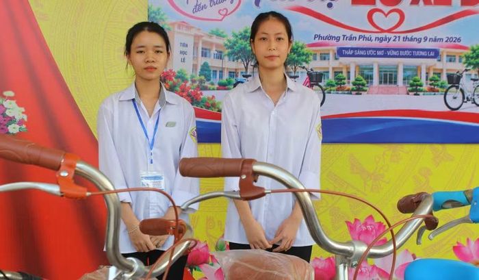 Em Nguyễn Thị Duyên - học sinh lớp 12 B12 (bên phải) bên chiếc xe đạp mới.