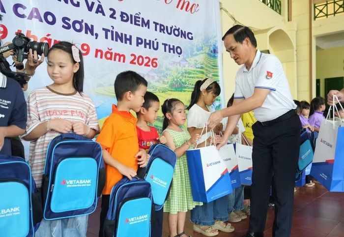 Ông Đoàn Hùng Sơn, Phó Giám đốc Ngân hành Nhà nước Khu vực 1 trao quà cho các em học sinh.