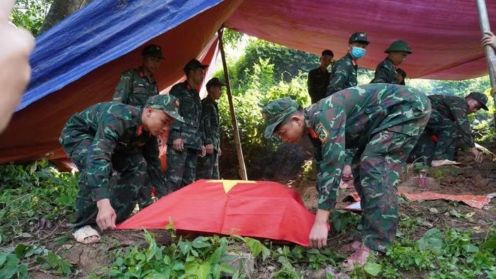 Lực lượng quân đội thực hiện nghi thức cất bốc hài cốt liệt sĩ.