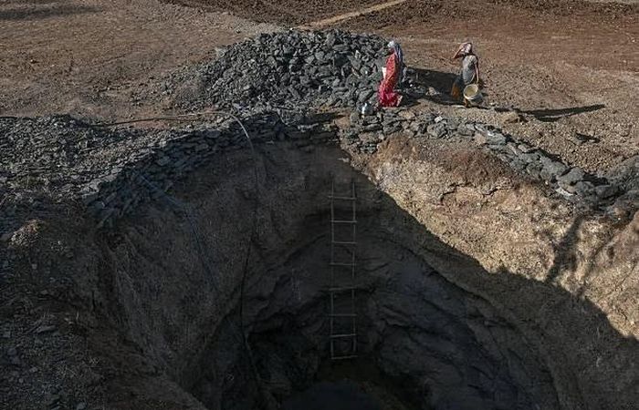 Người dân lấy nước từ một giếng gần cạn tại một ngôi làng chịu ảnh hưởng của hạn hán ở huyện Valsad, bang Gujarat, Ấn Độ, ngày 27/5. (Nguồn: Getty Images)