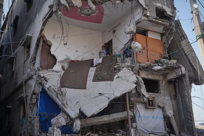  Người Palestine phải di dời khỏi một tòa nhà bị hư hại nặng do xung đột Israel-Hamas tại thành phố Gaza, ngày 17/9. Gần một năm sau khi lệnh ngừng bắn giữa Israel và Hamas có hiệu lực, nhiều người Palestine tại Gaza vẫn phải sống trong những công trình bị hư hại nặng do thiếu nơi trú ẩn thay thế. Một tòa nhà nhiều tầng tại thành phố Gaza đổ sập ngày 16/9, khiến 21 người thiệt mạng. Trong khi đó, một phần mái của công trình khác cũng đổ xuống sau mưa, khiến 4 trẻ em bị thương nhẹ. Theo các tổ chức cứu trợ, tình trạng thiếu vật liệu xây dựng và nơi ở an toàn đang khiến nhiều gia đình phải quay trở lại những công trình có nền móng suy yếu, tường nứt và trần nhà xuống cấp. Văn phòng Điều phối các vấn đề nhân đạo của Liên hợp quốc (OCHA) cho biết, riêng trong tuần đầu tháng 9 đã xảy ra các vụ sập tại 5 địa điểm trú ẩn. Bên cạnh đó, Bộ Công chính Palestine cảnh báo, hơn 2.000 công trình khác có nguy cơ đổ sập. Các tổ chức nhân đạo cũng kêu gọi tăng cường vật liệu cải tạo nơi trú ẩn, thiết bị dọn dẹp đống đổ nát và các nguồn lực cần thiết vào Gaza. (Nguồn: Daily News) 