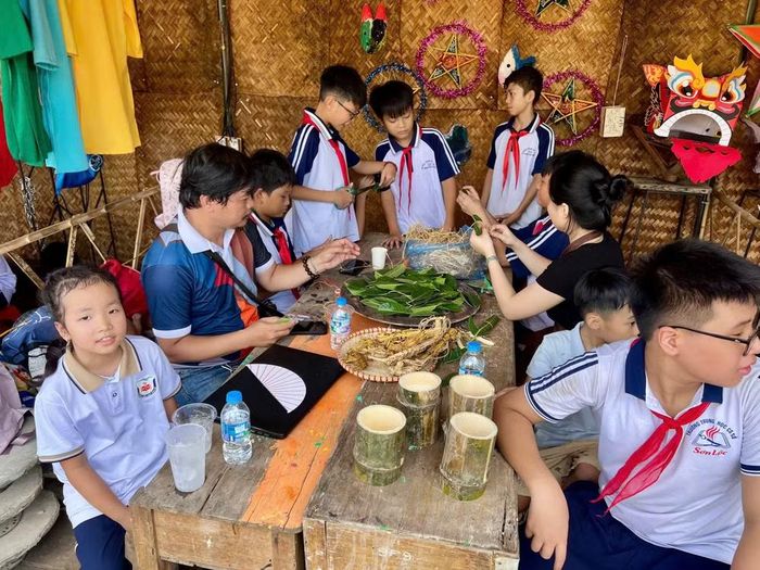 Các em nhỏ trải nghiệm làm trâu lá đa. Ảnh: Tấn Phát
