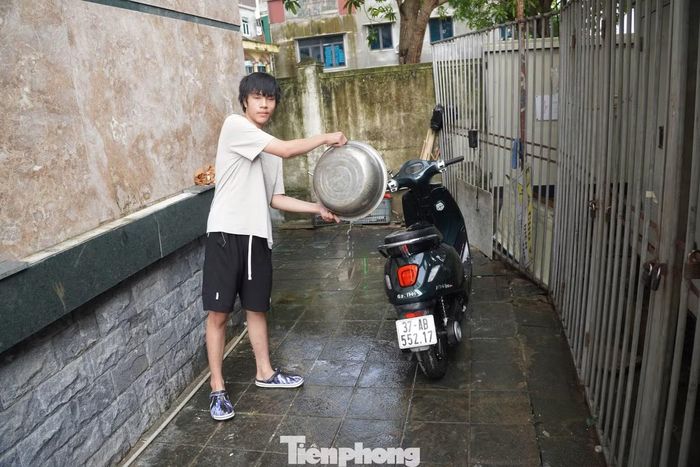 Người dân rửa sạch xe sau để sử dụng sau một ngày ngâm trong nước ở tầng hầm.