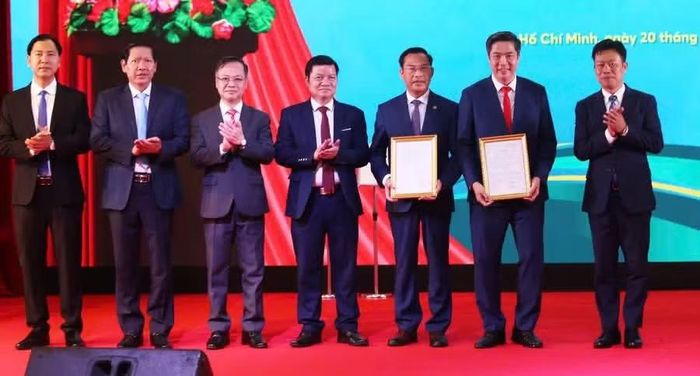 Thứ trưởng Bộ Giáo dục và Đào tạo Lê Quân (bìa phải) trao Quyết định thành lập và Quyết định cho phép hoạt động đào tạo của Phân hiệu Học viện Tài chính tại TPHCM. Ảnh: A.X