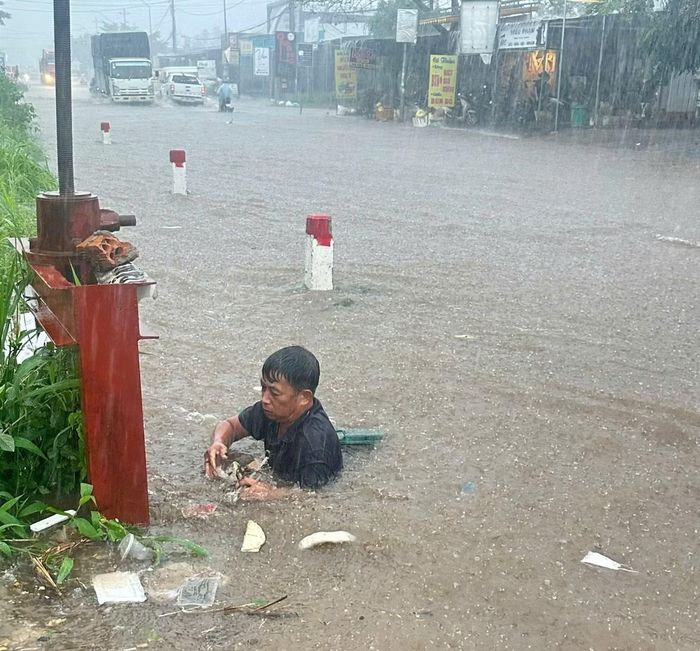 Ông Trần Văn Long xuống cống vớt rác, khơi thông dòng chảy.