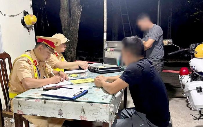 Lực lượng chức năng làm việc với tài xế vi phạm. Ảnh: Cục CSGT
