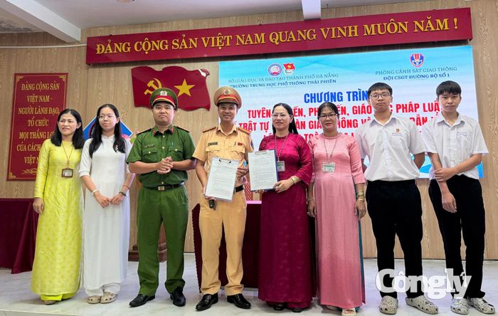 Cô Phạm Thị Trinh, Hiệu trưởng Trường THPT Thái Phiên (áo dài đỏ), cùng đại diện học sinh ký cam kết chấp hành các quy định về trật tự, an toàn giao thông.