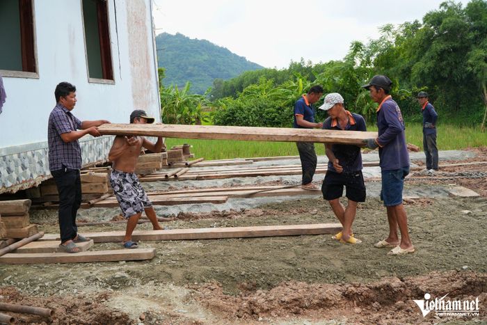 Công nhân lót các tấm ván gỗ để chuẩn bị di chuyển căn nhà trên con lăn.