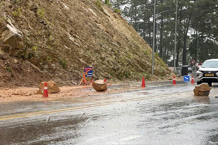 Sạt lở khiến đất đá và ba tảng đá lớn rơi xuống, chắn ngang mặt đường. Ảnh: Khánh Ngọc