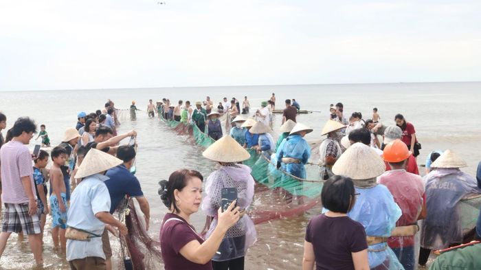 Du khách hào hứng ghi lại những khoảnh khắc đáng nhớ từ trải nghiệm kéo rùng trên biển Hải Tiến