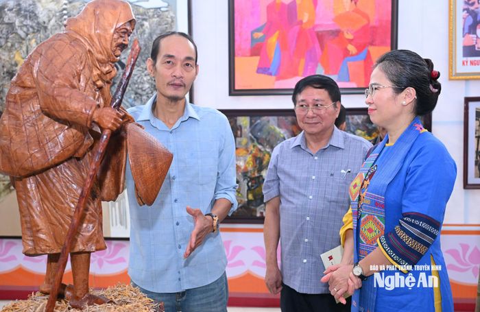 Phó Bí thư Tỉnh ủy Võ Thị Minh Sinh trò chuyện cùng tác giả tham dự triển lãm. Ảnh: Thành Cường