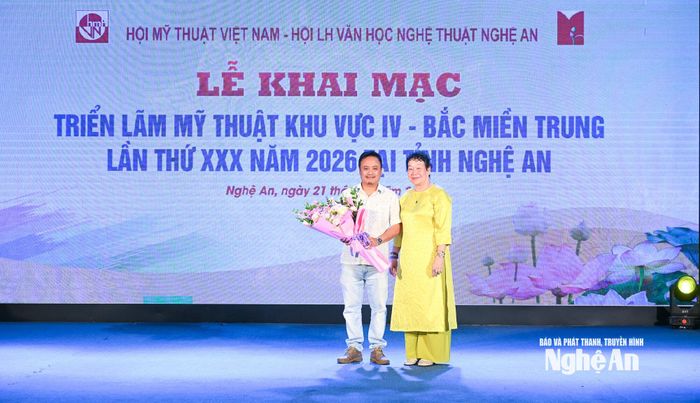 Ban Tổ chức tặng hoa, chúc mừng tác giả đạt Giải Nhất triển lãm. Ảnh: Thành Cường