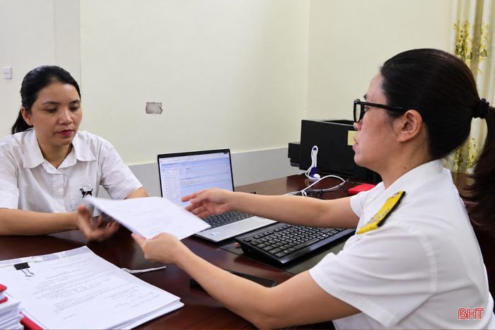 Cán bộ thuế hướng dẫn người nộp thuế rà soát, hoàn thiện hồ sơ.