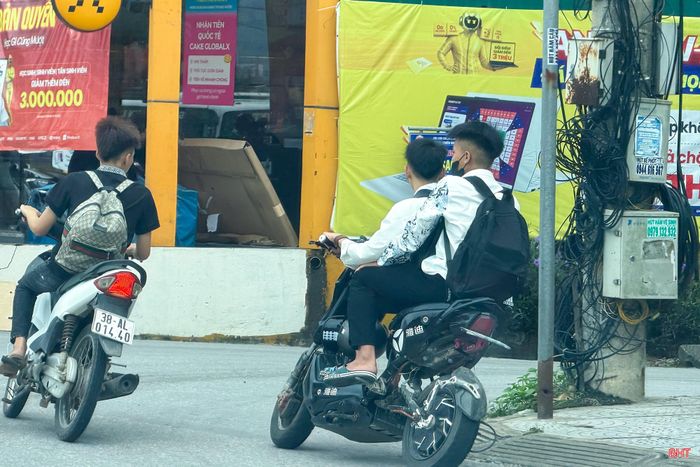  Học sinh không đội mũ bảo hiểm di chuyển trên tuyến quốc lộ 1 qua địa bàn xã Can Lộc. 