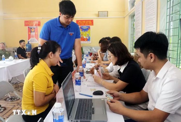 Cán bộ Trung tâm Phục vụ hành chính công phường Lý Thường Kiệt (Ninh Bình) hướng dẫn người dân sử dụng các nền tảng số trong thực hiện thủ tục hành chính. (Ảnh: Nguyễn Chinh/TTXVN)