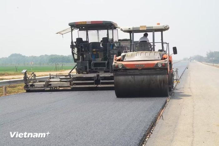 Nhà thầu thi công thảm bê tông nhựa nền đường. (Ảnh: Việt Hùng/Vietnam+)