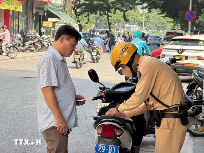 Lực lượng Cảnh sát giao thông kiểm tra xe hợp đồng trong đợt tăng cường xử lý phương tiện dừng, đỗ, đón trả khách không đúng quy định sáng 21/9. (Ảnh: Trung Nguyên/TTXVN)