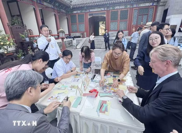 Các phóng viên, nhà báo nước ngoài tại Bắc Kinh trải nghiệm văn hóa của Trung Quốc. (Ảnh: Công Tuyên/TTXVN)