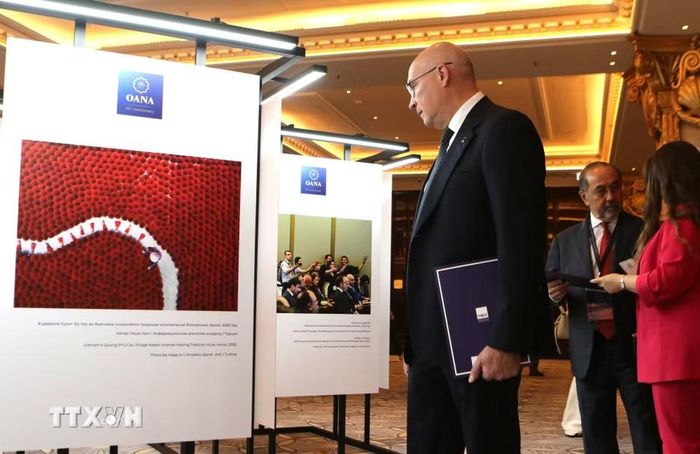Tổng Giám đốc Hãng thông tấn TASS của Nga Andrey Kondrashov chăm chú ngắm bức ảnh về Làng hương truyền thống Quảng Phú Cầu của Việt Nam. (Ảnh: Văn Hiếu/TTXVN)