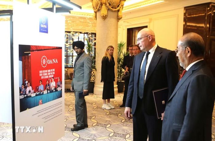 Tổng Giám đốc hãng thông tấn TASS Andrey Kondrashov và đồng nghiệp xem bức ảnh lịch sử về sự kiện OANA được tổ chức tại Hà Nội vào năm 1989. (Ảnh: Văn Hiếu/TTXVN)