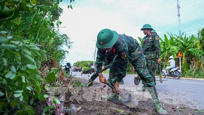 Lực lượng chức năng phối hợp phát quang cây cối, chỉnh trang tuyến đường, góp phần bảo đảm cảnh quan và giao thông nông thôn. Ảnh: Minh Phú - TTXVN