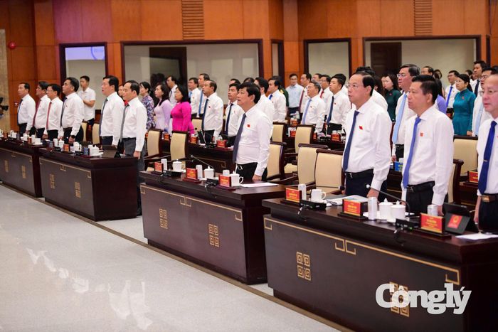 Các đại biểu thực hiện nghi thức chào cờ trước khi bắt đầu kỳ họp. Ảnh: Quang Định.