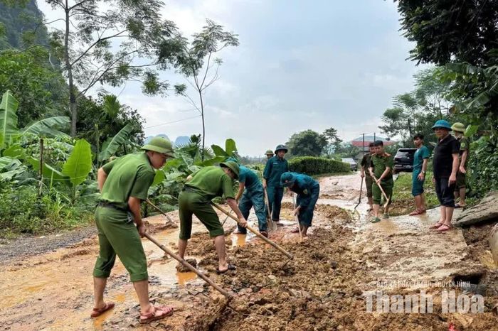 Lực lượng chức năng hỗ trợ người dân vùng lũ dọn dẹp vệ sinh môi trường sau lũ tại xã Ngọc Lặc.