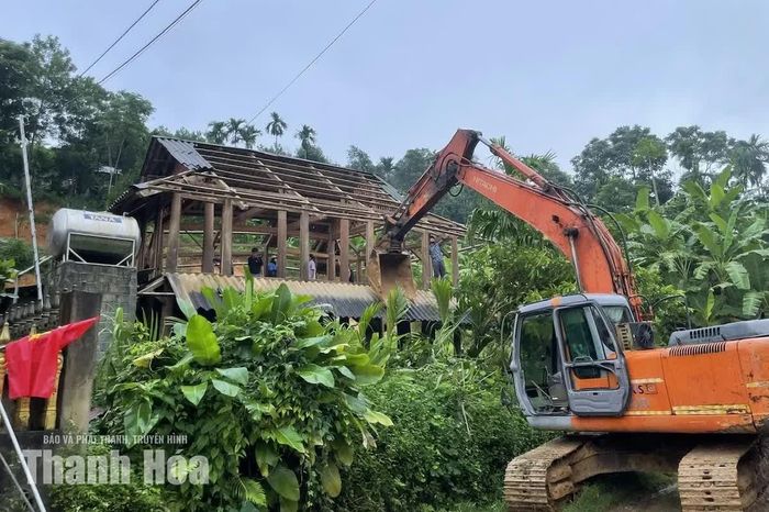 Huy động máy móc hỗ trợ các hộ dân dọn dẹp đất đá sạt lở vào nhà.