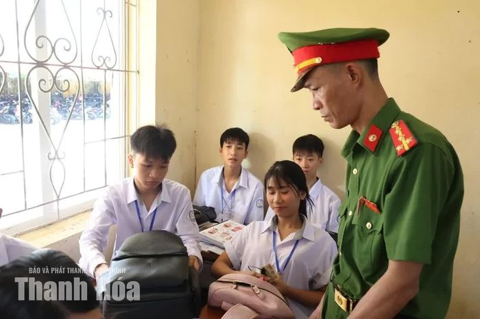 Cán bộ Công an xã Hoằng Hóa kiểm tra cặp sách của học sinh.