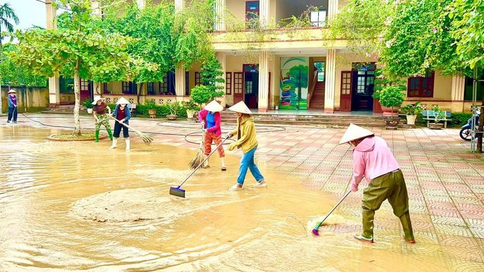 Cán bộ, giáo viên Trường THCS Nông Cống, phân hiệu Vạn Thiện khẩn trương vệ sinh trường học sau khi nước lũ rút. Ảnh: Nguyễn Thuấn