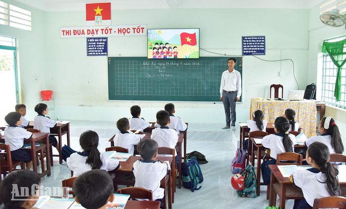 Thầy Đinh Trung Quân sử dụng bài giảng trình chiếu trên tivi để hỗ trợ học sinh theo kịp nội dung bài học khi chưa có đủ sách giáo khoa.