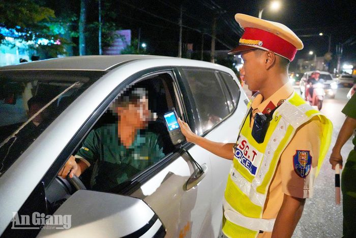 Cán bộ cảnh sát giao thông kiểm tra nồng độ cồn của tài xế lái ô tô trên đường Trần Hưng Đạo, đặc khu Phú Quốc.