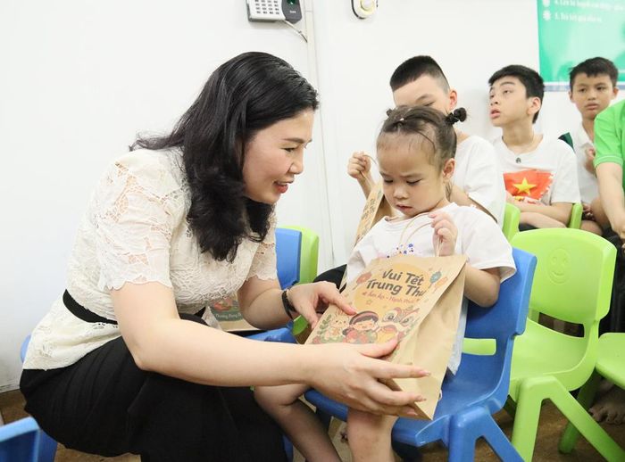  Đồng chí Trần Thị Vân ân cần trao quà cho các em nhỏ tại Trung tâm. 
