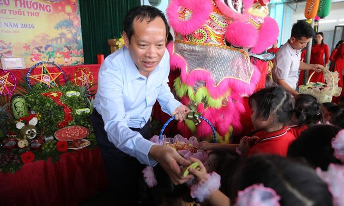  Đồng chí Nghiêm Xuân Hưởng phát bánh kẹo cho học sinh vui đón Trung thu.  
