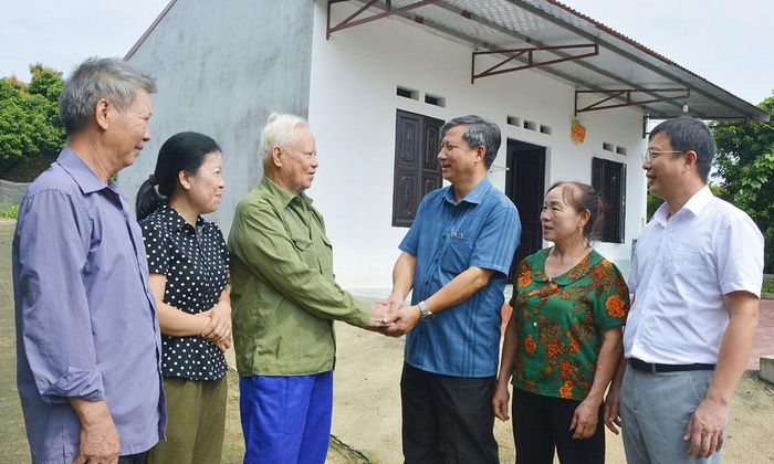Đồng chí Đinh Công Hưng, Bí thư Đảng ủy, Chủ tịch HĐND xã Xuân Lương (thứ ba từ phải sang) thăm hỏi ông Lý Văn Dịp, bản Trại Sông khi ông được hỗ trợ xây dựng nhà mới.