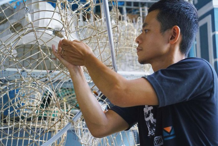 Người thợ liên tục căn chỉnh tỷ lệ, độ cong để bộ khung giữ được hình dáng cân đối. Ảnh: TRÂM ANH - HỮU TRUNG