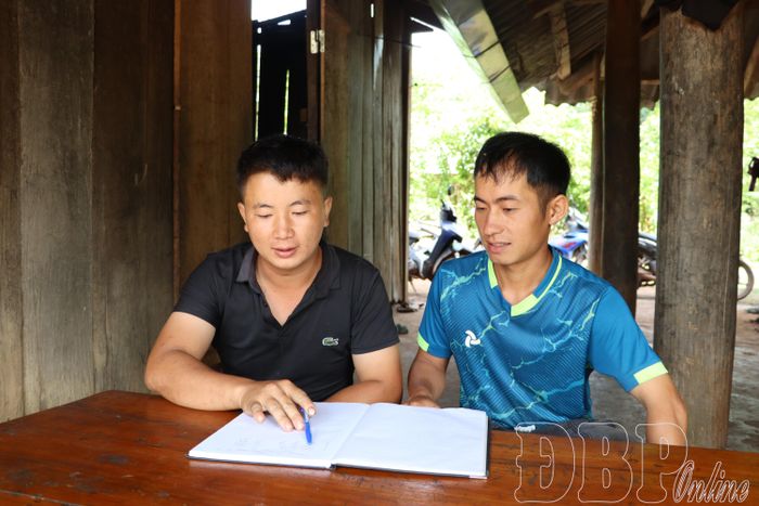  Bí thư Chi bộ bản Nậm Là (bên trái) trò chuyện với quần chúng ưu tú của bản, tạo nguồn kết nạp đảng viên mới.