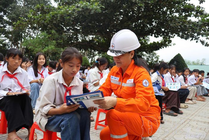 Cán bộ Điện lực Điện Biên Phủ hướng dẫn học sinh tìm hiểu tài liệu, nhận diện các tình huống mất an toàn trong sử dụng điện.