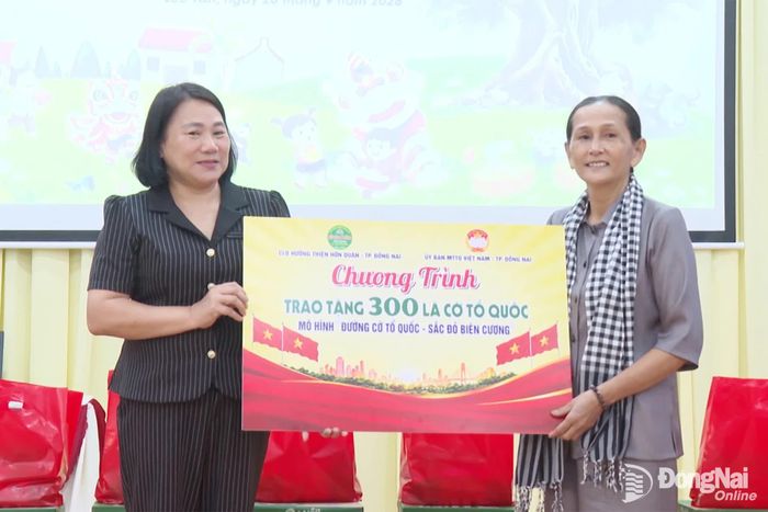 Câu lạc bộ Hướng thiện Hớn Quản trao tặng cờ Tổ quốc thực hiện mô hình “Đường cờ Tổ quốc, sắc đỏ biên cương”. Ảnh: Trần Cảnh
