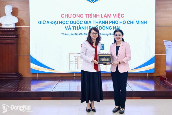 Ủy viên Trung ương Đảng, Phó Bí thư Thường trực Thành ủy, Chủ tịch HĐND thành phố Tôn Ngọc Hạnh nhận quà lưu niệm từ GS.TS Nguyễn Thị Thanh Mai, Ủy viên Trung ương Đảng, Giám đốc Đại học Quốc gia Thành phố Hồ Chí Minh. Ảnh: Công Nghĩa